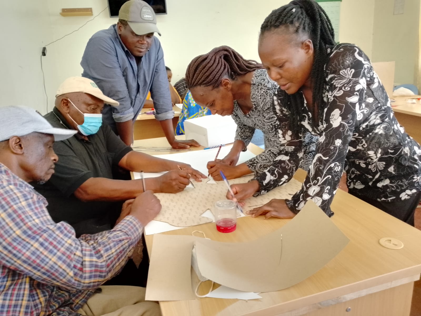 UDPL members cutting and measuring khaki fabric for reusable bags